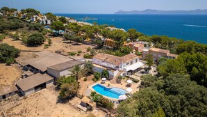 Un quartier résidentiel situé sur la côte, doté d’une piscine, de maisons et offrant une vue dégagée sur la mer.