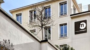 Ein mehrgeschossiges Gebäude mit einem Balkon im oberen Stockwerk.