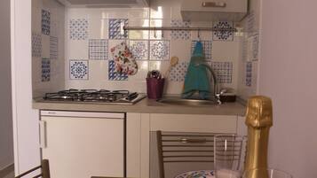 Een koelkast, een oven, een kookplaat, een koffiezetapparaat/waterkoker