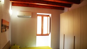 Une chambre à coucher avec un lit, une armoire et une fenêtre.