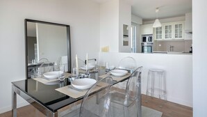 Una cocina moderna con armarios blancos y electrodomésticos de acero inoxidable.
