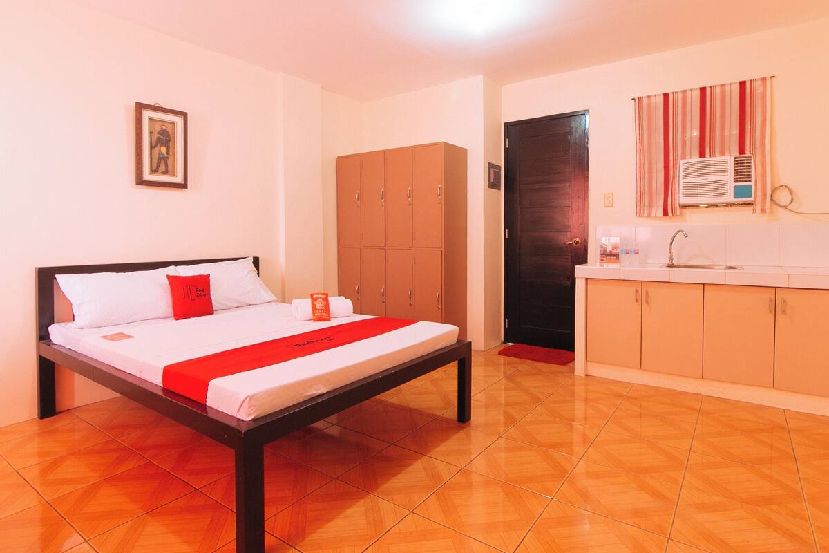 Une chambre d’hôtel comprenant un lit, une armoire, une salle de bain avec douche et un lavabo.