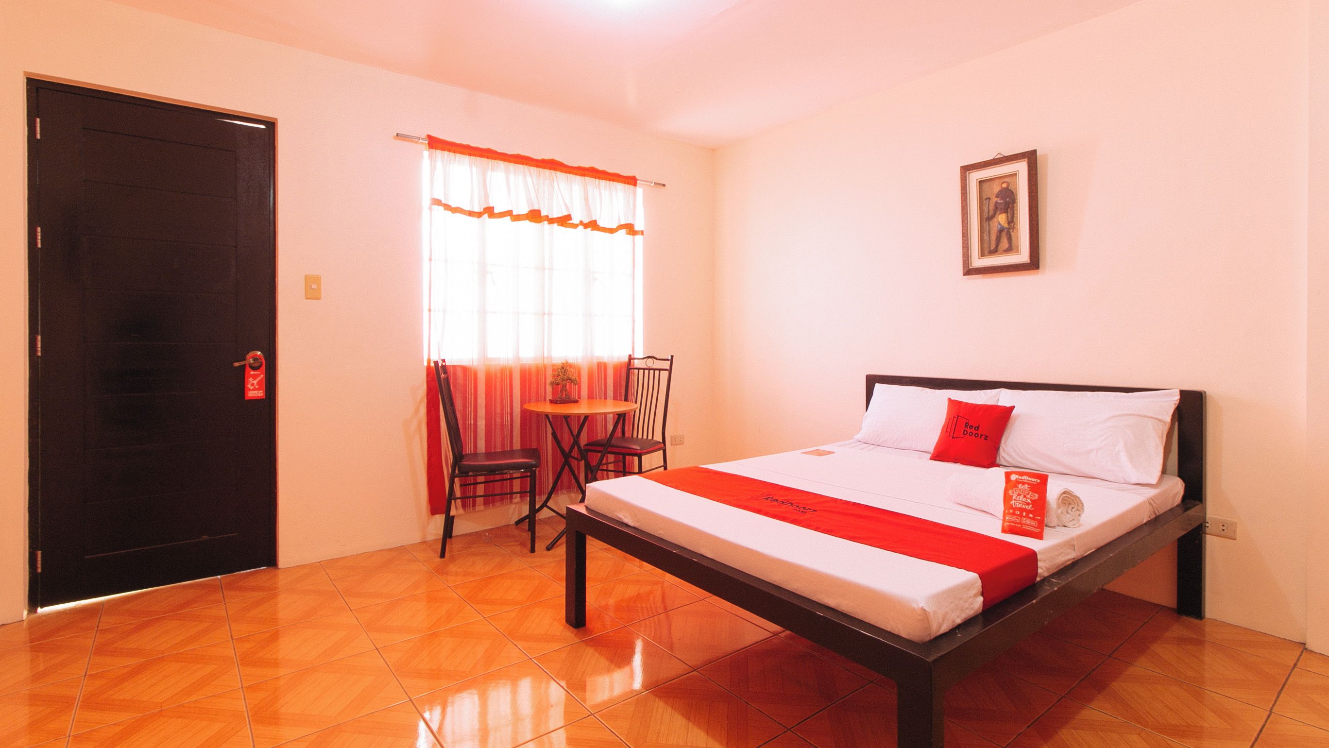 Une chambre d’hôtel avec un lit, une chaise, une table et une porte.