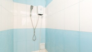 Un baño con ducha, inodoro y dispensador de jabón en la pared.