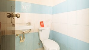 A bathroom with a toilet, sink, and a door. - Reddoorz @ FDB Homes Nueva Ecija (San Jose City)
