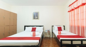A hotel room with two beds, a wardrobe, a small table with toiletries, and a framed picture on the wall. - Reddoorz @ FDB Homes Nueva Ecija (San Jose City)