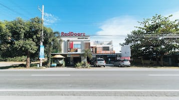 A commercial building with multiple storefronts, including RedDoorz and fdb Homes.
