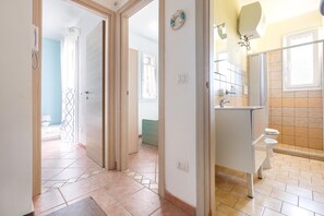 Un baño con inodoro, lavabo y zona de ducha.