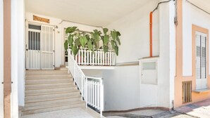 A staircase with white railings leading to a landing with potted plants. - 2186 Attico Demetra (Avetrana)