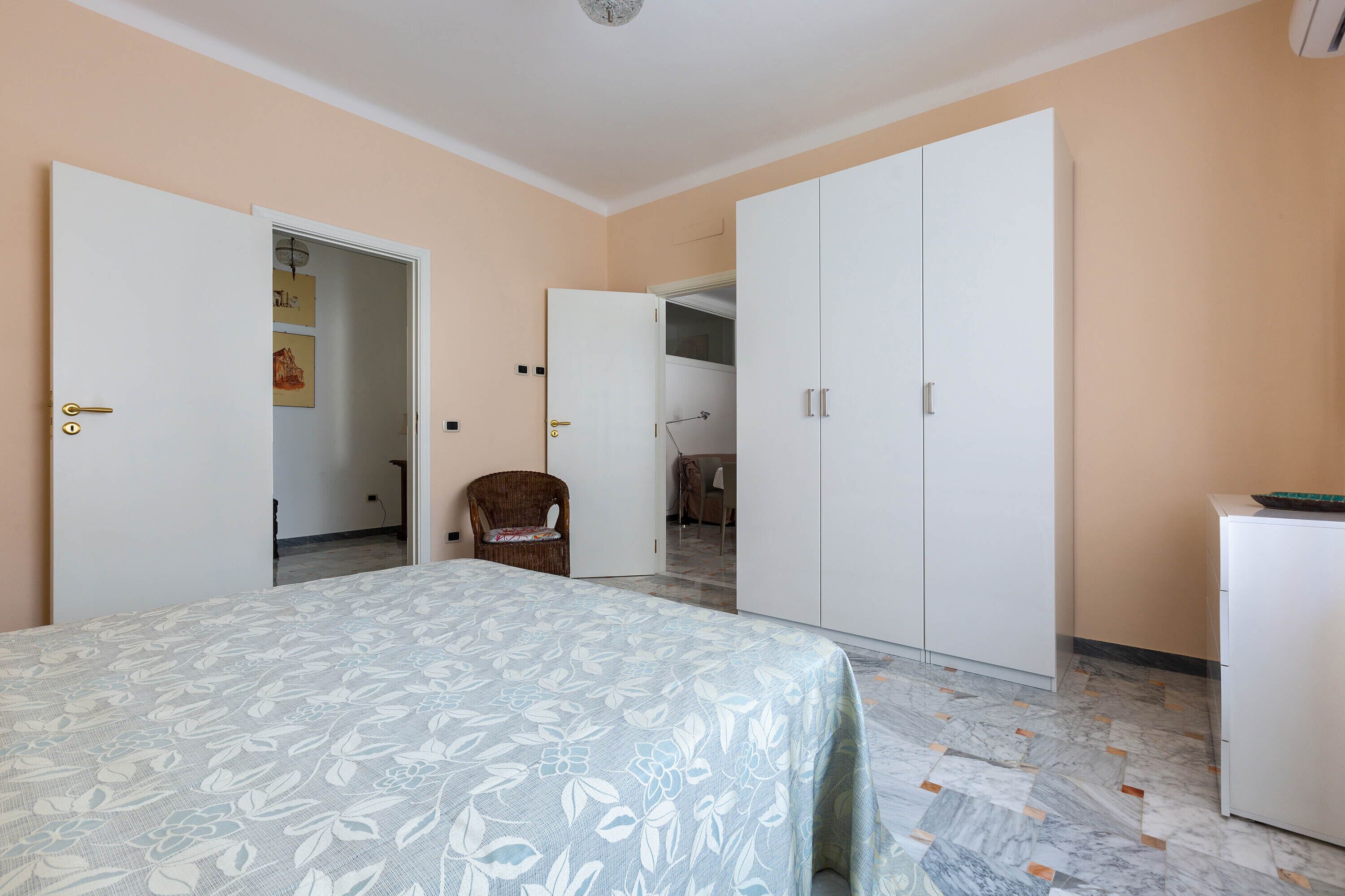 A bedroom with a bed, wardrobe, and a chair.