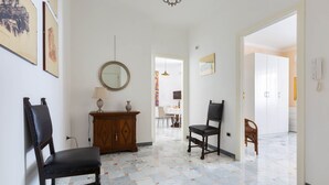 A hallway with two chairs, a wooden cabinet, and a mirror on the wall. - 2150 Casa Mandù (Manduria)