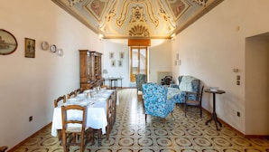 A dining room with a long table set for a meal, a patterned floor, and a decorative ceiling. - 2163 Palazzo Grassi (Martina Franca)