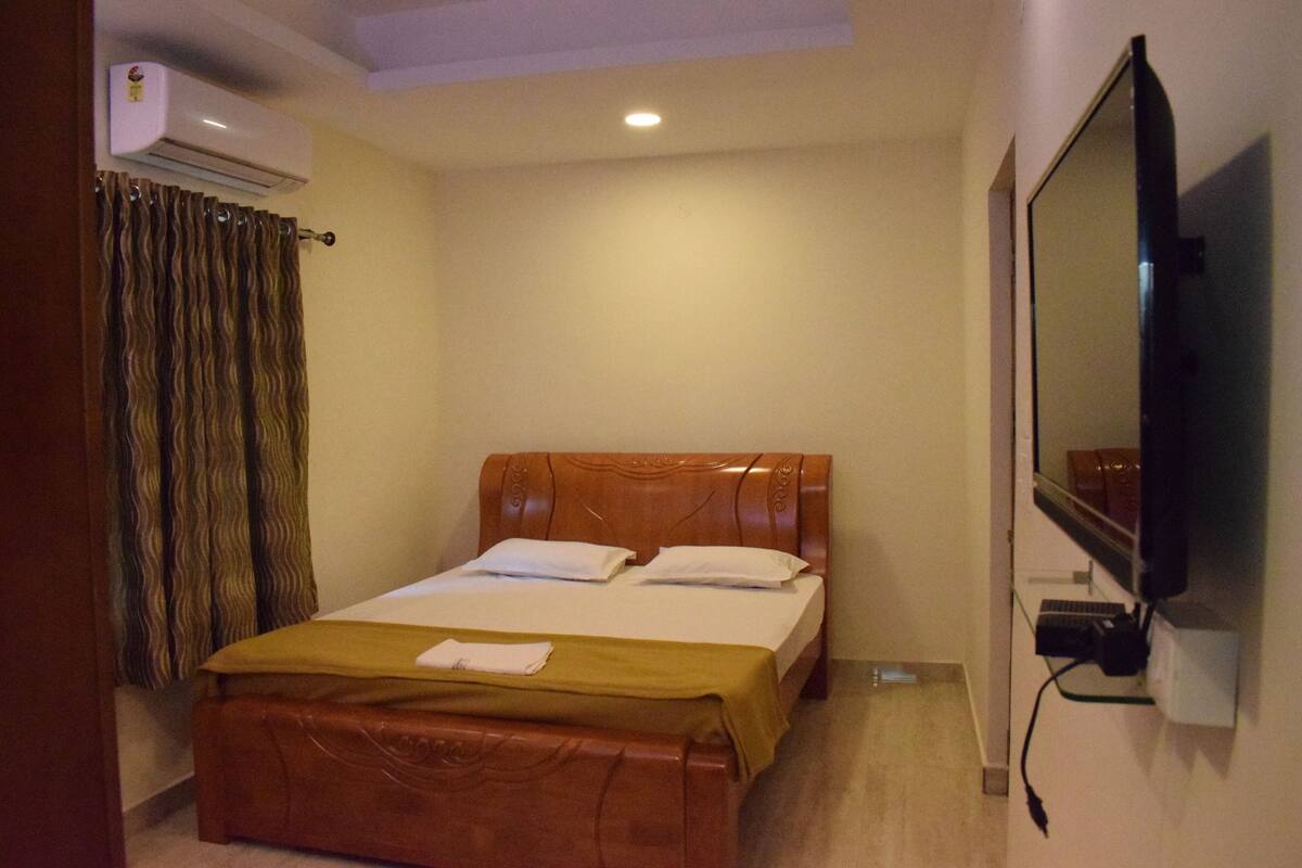 Ein Schlafzimmer mit einem Bett, einem Fernseher und einer Klimaanlage.