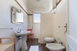 A bathroom with a sink, mirror, toilet, and a window. - 2084 Villa Graziana (Manduria)