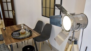A dining area with a wooden table, black chairs, and a modern pendant light. - Alohamundi San Leandro (Sevilla)