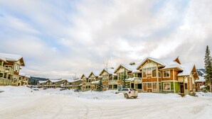 Una località turistica innevata con edifici a più piani, un'area di parcheggio e un paesaggio ricoperto di neve.