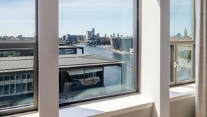 A view from a window overlooking a river with buildings and a city skyline. - NH Collection Copenhagen (Copenhagen)