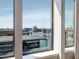 A view from a window overlooking a river with buildings and a city skyline.