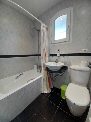 Een bad, een haardroger, handdoeken, zeep