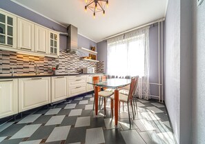 Enjoy casual gatherings around the central island with four chairs, surrounded by modern cabinetry and a stylish backsplash.