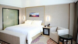 A hotel room with a large bed, a sofa, a small table, and a painting on the wall. - Lavande Hotel Shenzhen Shiyan Bus Station (Shenzhen)