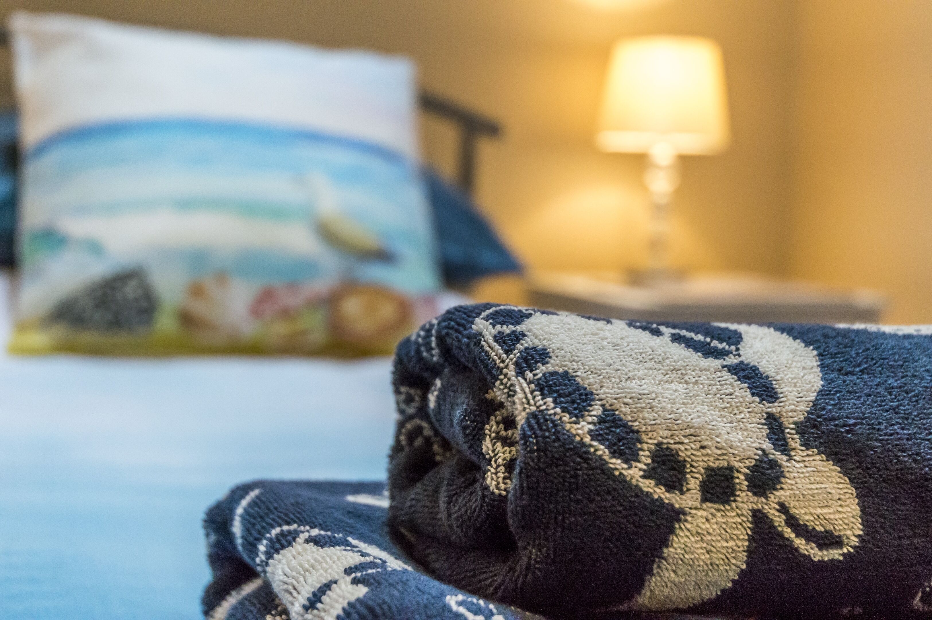 Una cama con un edredón estampado y una almohada con diseño de playa.