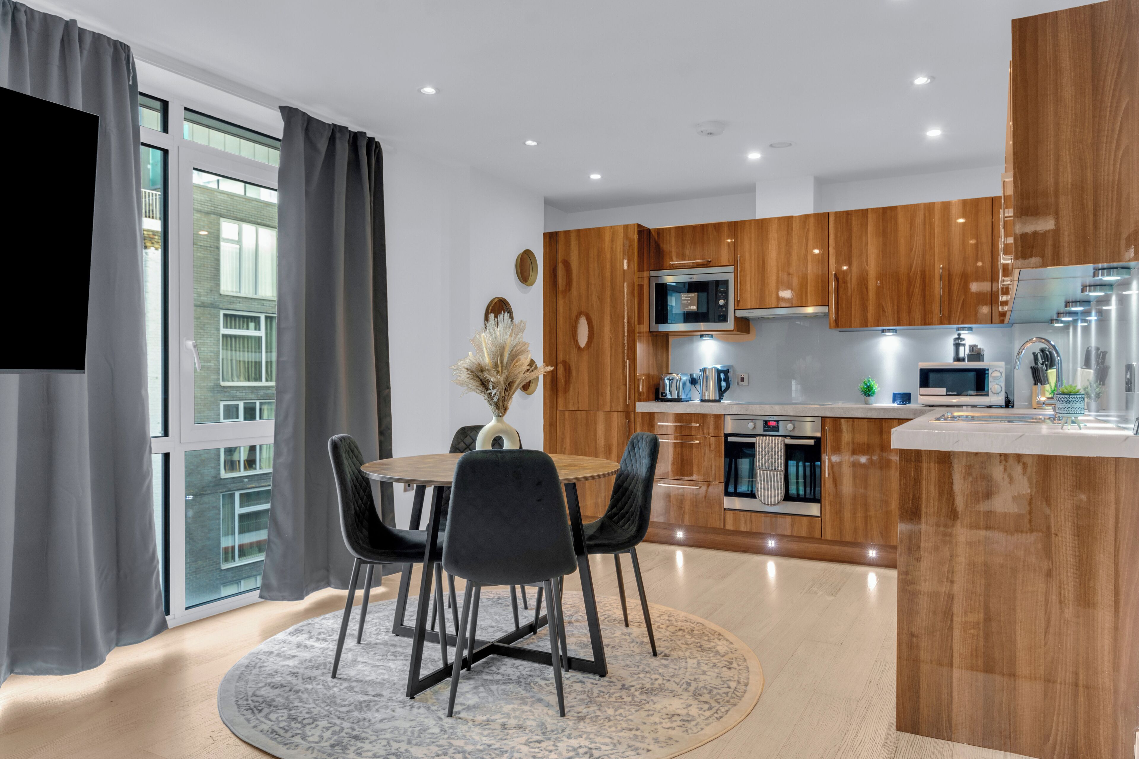 A modern kitchen with wooden cabinets, a microwave, and a built-in oven.