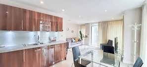 Enjoy a sleek kitchen, dining area, and cozy living space in this stylish apartment.