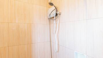 Una ducha con un cabezal de ducha de mano montado en la pared.