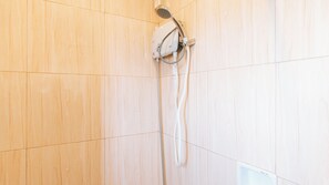 A shower with a handheld showerhead mounted on a wall. - Reddoorz Near Christ the King Medical Center (Las Pinas)