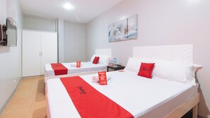 A hotel room with two beds, a flat-screen TV, and a painting on the wall. - Reddoorz Near Christ the King Medical Center (Las Pinas)