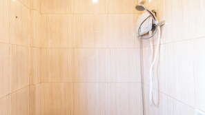 A shower area with a handheld showerhead and a hose. - Reddoorz Near Christ the King Medical Center (Las Pinas)