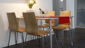 A modern dining area with a table, chairs, and artwork on the wall. - Apartment Colom 1- (Barcelona)
