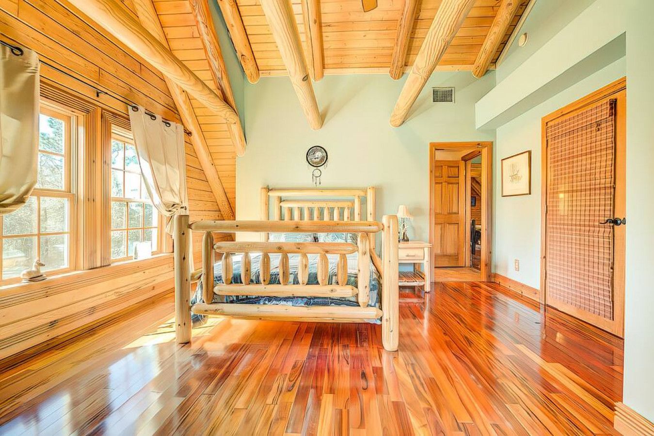 A spacious room with wooden floors, a bunk bed, large windows, and a traditional Japanese shoji screen.