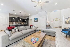 A modern living room with a sectional sofa, a coffee table, and a blue armchair.