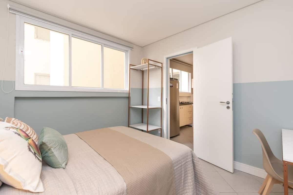 Une chambre à coucher avec un lit, une fenêtre, une armoire et un bureau.