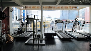A gym with treadmills, exercise bikes, and a mirrored wall. - Reddoorz @ The Providence Tower (Manila)