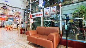 A RedDoorz store with a brown leather couch in front, a glass display case, and a sign advertising a safe and comfortable stay. - Reddoorz @ The Providence Tower (Manila)