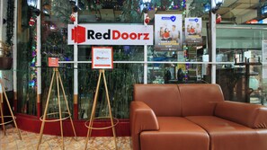 Un letrero de RedDoorz, un logotipo de RedDoorz, un cartel con la página web de RedDoorz y un letrero de socio de RedDoorz.