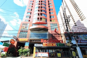 A multi-story building with various commercial establishments on the ground floor, including a fitness center and a restaurant. - Reddoorz @ The Providence Tower (Manila)