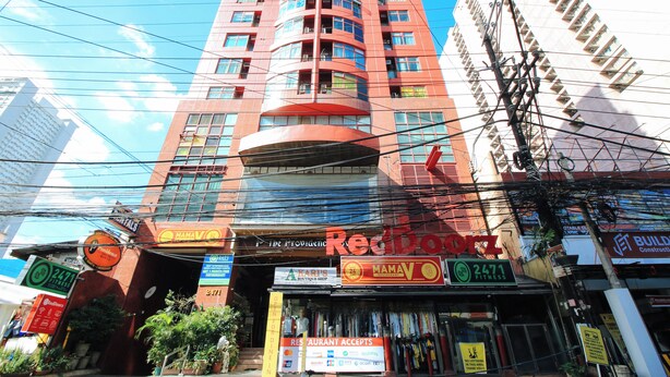 A multi-story building with various commercial establishments on the ground floor, including a fitness center and a restaurant. - Reddoorz @ The Providence Tower (Manila)