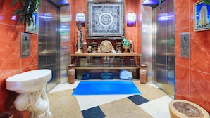 A bathroom with a marble floor, a sink, a mirror, and a decorative shelf with various items. - Reddoorz @ The Providence Tower (Manila)
