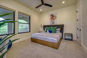 A bedroom with a bed, a ceiling fan, a window, and a door. - Boaters and Golfers Dream Luxury Lakeside Villa (Sunrise Beach Village)