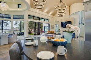 Una cucina moderna con zona pranzo, ampie finestre e vista sull'esterno.