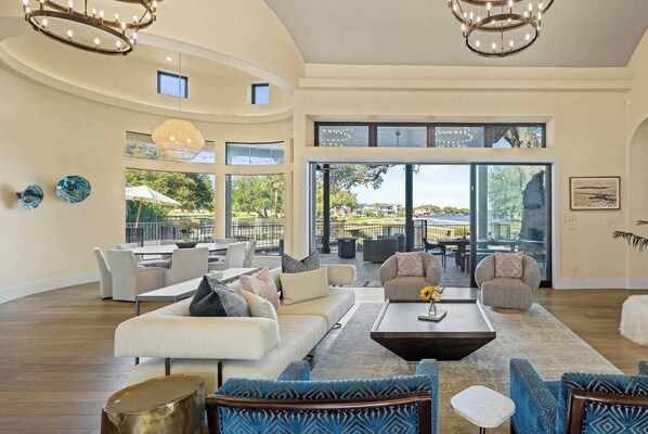 A spacious living room with a large window, a dining area, and a view of the outdoors.
