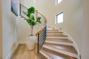 A spiral staircase with wooden steps and a metal railing, a potted plant, and a small window. - Boaters and Golfers Dream Luxury Lakeside Villa (Sunrise Beach Village)
