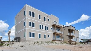 A multi-story building with a flat roof, multiple balconies, and a sandy ground. - Oceanfront 9BR Ponte Vedra Estate with Private Beach Access. Sleeps 20! (Ponte Vedra)