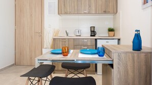 A compact kitchen with wooden cabinets, a coffee maker, and a small countertop. - Mikes Beach Lux (Hersonissos)