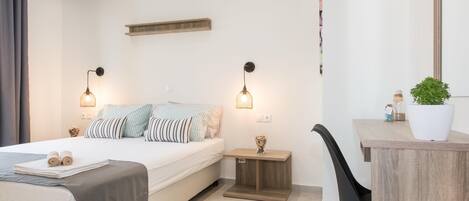 A modern bedroom with a bed, bedside tables, a desk, and a chair.