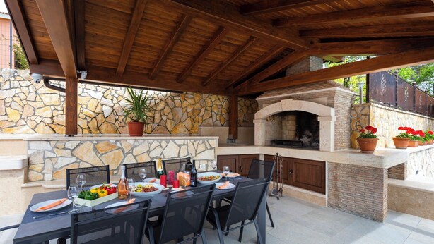 An outdoor patio with a stone wall, a wooden ceiling, and a built-in grill. - Villa Vita in Poreč  - Haus für 6-8 Personen (Kaštelir)